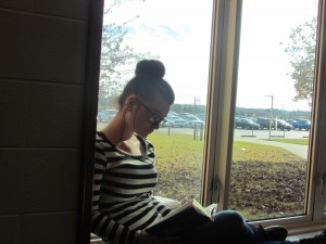 Jennifer Butler, senior at LCHS, enjoys sitting in the library window, to read a good book.